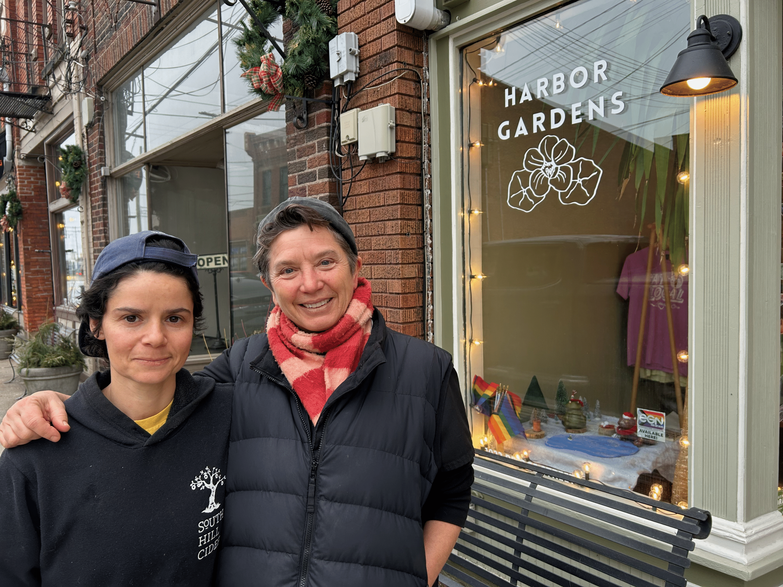 Sarah Brower and T. Gallo stand together in front of Harbor Gardens in Ashtabula, Ohio. T. Gallo has their arm around Sarah Brower.