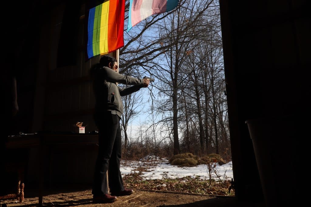 Allie braces herself and points her gun at the snowy ridge as the sun begins to set.