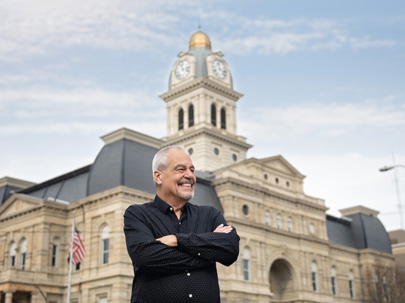 Jeff Givan crosses his arms and smiles to the right of the frame.