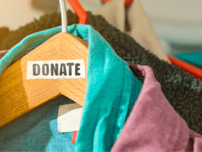 The stock image shows clothes in (coincidentally) trans Pride colors hanging on a wooden hangar. A label is on the hangar that reads "DONATE."
