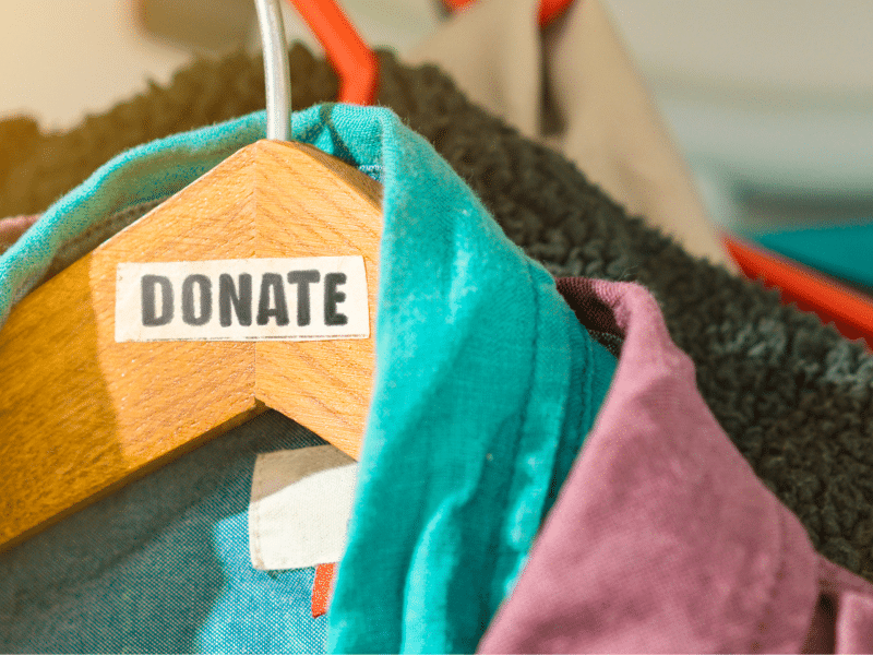 The stock image shows clothes in (coincidentally) trans Pride colors hanging on a wooden hangar. A label is on the hangar that reads "DONATE."
